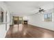 Living room with hardwood floors, fireplace, ceiling fan, slider door to balcony, and view into kitchen at 3050 W 32Nd Ave # 104C, Denver, CO 80211
