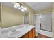 Bathroom featuring a double sink vanity and a shower with glass doors at 4267 W Kenyon Ave, Denver, CO 80236
