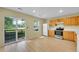 The kitchen features modern appliances, light wood cabinets, and access to the outdoors through sliding glass doors at 4267 W Kenyon Ave, Denver, CO 80236