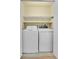 Brightly lit laundry area with modern washer and dryer units and shelving at 4267 W Kenyon Ave, Denver, CO 80236
