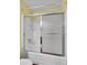 Close-up of bathtub and shower combination, featuring a frosted glass sliding door at 4267 W Kenyon Ave, Denver, CO 80236