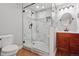 Modern bathroom featuring a glass shower with marble tiling and wood cabinets at 5740 S Tempe Ct, Aurora, CO 80015