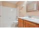 Bathroom featuring a single vanity, shower over tub, and white tiling at 5740 S Tempe Ct, Aurora, CO 80015