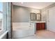 A serene bathroom offers a soaking tub, a dual vanity with framed mirrors, and soft lighting at 5740 S Tempe Ct, Aurora, CO 80015