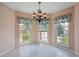 A cozy dining area features three large windows with curtains, allowing plenty of natural light at 5740 S Tempe Ct, Aurora, CO 80015