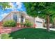 A well-manicured lawn and landscaping accentuate this single Gathering home with an attached garage at 5740 S Tempe Ct, Aurora, CO 80015