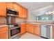 A well-lit kitchen features stainless steel appliances, light wood cabinets, and ample counter space at 5740 S Tempe Ct, Aurora, CO 80015