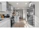 Bright kitchen with stainless steel appliances, white cabinets and a view of the dining area at 4910 Alcott St, Denver, CO 80221