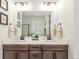 Bathroom features a dual-sink vanity with modern fixtures, white countertops, and decorative framed prints at 22773 E Narrowleaf Cir, Aurora, CO 80016