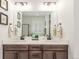 Bathroom featuring double sinks, dark wood cabinets, a large mirror, and modern lighting at 22773 E Narrowleaf Cir, Aurora, CO 80016