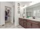 Bathroom featuring double vanity, quartz countertop, tiled floor, and walk-in closet at 22773 E Narrowleaf Cir, Aurora, CO 80016