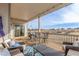 A covered outdoor deck has a dining area and comfortable seating overlooking a scenic landscape at 22773 E Narrowleaf Cir, Aurora, CO 80016