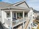 Aerial view of the rear of a home featuring a spacious deck, lower patio, and stylish outdoor lighting at 22773 E Narrowleaf Cir, Aurora, CO 80016