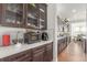 Kitchen area featuring dark cabinets with see through doors and white countertop with modern appliances at 22773 E Narrowleaf Cir, Aurora, CO 80016