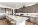 Well-lit kitchen featuring dark wood cabinets, stainless steel appliances, and island with barstool seating at 22773 E Narrowleaf Cir, Aurora, CO 80016