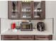 Modern kitchen area with dark cabinets and see-through doors and white countertops with appliances at 22773 E Narrowleaf Cir, Aurora, CO 80016