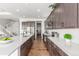 Modern kitchen with dark wood cabinets, white countertops, stainless steel appliances, and hardwood floors at 22773 E Narrowleaf Cir, Aurora, CO 80016