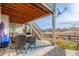 Covered patio with outdoor dining set and lounge area below a wooden deck and stairs at 22773 E Narrowleaf Cir, Aurora, CO 80016