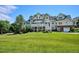 Expansive backyard with manicured lawn, multiple decks, and a large elegant house in the background at 8717 Ridgepoint Dr, Castle Pines, CO 80108