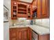 Wet bar area features custom wood cabinetry, granite countertop, wine storage, and a built-in refrigerator at 8717 Ridgepoint Dr, Castle Pines, CO 80108