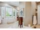 Luxurious bathroom with marble floors, a soaking tub under a large window, and custom vanity at 8717 Ridgepoint Dr, Castle Pines, CO 80108
