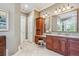 Bathroom area with cherry wood vanity, granite countertop, double mirrors, and tiled floors at 8717 Ridgepoint Dr, Castle Pines, CO 80108