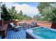 Outdoor deck with a hot tub, comfortable seating, and a brick railing overlooking the backyard at 8717 Ridgepoint Dr, Castle Pines, CO 80108