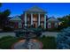 Elegant home exterior with a large fountain, manicured landscaping, and a grand facade under a twilight sky at 8717 Ridgepoint Dr, Castle Pines, CO 80108