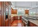 Kitchen features stainless appliances, cherry cabinetry, granite counters, and a professional-grade gas cooktop at 8717 Ridgepoint Dr, Castle Pines, CO 80108