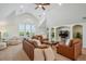 Spacious living room filled with leather furniture, large windows, and a built-in bookcase at 8717 Ridgepoint Dr, Castle Pines, CO 80108