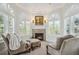Cozy living room features a fireplace, two arched windows with shutters, and comfortable upholstered armchairs at 8717 Ridgepoint Dr, Castle Pines, CO 80108