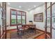Wood-paneled office with a large window, desk, and hardwood floors covered with an oriental rug at 8717 Ridgepoint Dr, Castle Pines, CO 80108