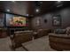 Home theater room with large screen, comfortable seating, and dark walls at 8717 Ridgepoint Dr, Castle Pines, CO 80108