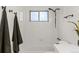 A bright white tiled bathroom with contrasting dark fixtures and shower-tub combo at 1327 E 108Th Pl, Northglenn, CO 80233