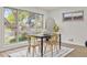 Bright dining room features large window views, modern rug, and natural-wood chairs around black table at 1327 E 108Th Pl, Northglenn, CO 80233