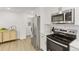 Modern kitchen with stainless steel appliances and ample counter space adjacent to hall at 1327 E 108Th Pl, Northglenn, CO 80233