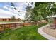 Well maintained backyard with green lawn, gravel landscaping, privacy fence and view of nearby buildings at 15565 Flowerhill Cir, Parker, CO 80134