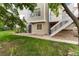 Manicured backyard with partial privacy fence, green grass, side patio, and exterior stair access to the deck at 15565 Flowerhill Cir, Parker, CO 80134