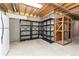 Unfinished basement with concrete walls and floors with exposed ceiling beams, shelving units, and refrigerator at 15565 Flowerhill Cir, Parker, CO 80134