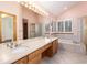 Well-lit bathroom featuring double sinks, a bathtub, and a shower with glass doors, offering relaxation at 15565 Flowerhill Cir, Parker, CO 80134