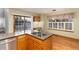 Kitchen island features a granite countertop, sink and wood cabinets, and a sliding glass door in the background at 15565 Flowerhill Cir, Parker, CO 80134