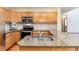 This kitchen features granite countertops, wood cabinets, stainless steel appliances and tile backsplash at 15565 Flowerhill Cir, Parker, CO 80134