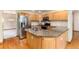 This bright kitchen features stainless steel appliances, granite countertops, wood cabinets, and a large island at 15565 Flowerhill Cir, Parker, CO 80134