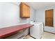 Functional laundry room with a modern washer and dryer, complemented by a countertop and storage at 15565 Flowerhill Cir, Parker, CO 80134