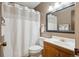 This bathroom has a tub/shower, a toilet, a wooden vanity and large mirror at 1799 S Lee St # B, Lakewood, CO 80232