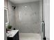 Bathroom features modern black matte fixtures, white marble tiling, and a shower-tub combo at 1263 N Willow St, Denver, CO 80220