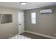 Bedroom with a decorative mirror on the wall, mini split air conditioning and a window with blinds at 1263 N Willow St, Denver, CO 80220