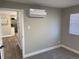 Bedroom with mini split air conditioning, gray carpet, and view of the kitchen through the door at 1263 N Willow St, Denver, CO 80220
