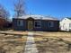 Charming home featuring a yellow door, gray siding, and well-maintained lawn at 1263 N Willow St, Denver, CO 80220