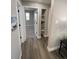 Hallway with laminate flooring, built-in shelving, and views into adjacent rooms at 1263 N Willow St, Denver, CO 80220